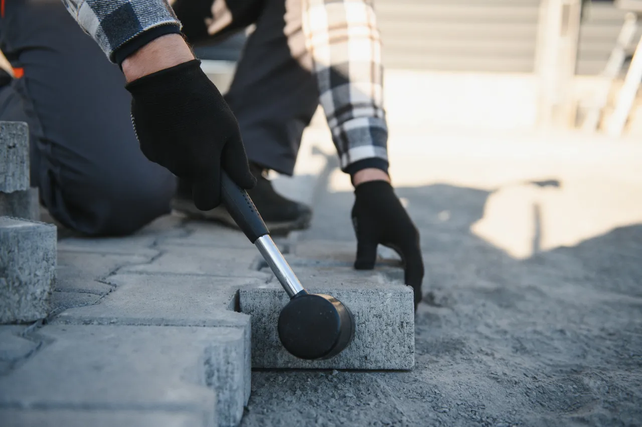 Worker using mallet to lay pavers in New Jersey