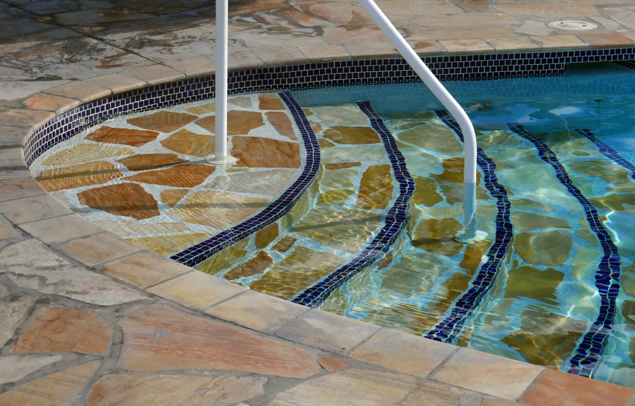 Steps leading into a swimming pool with coping edge in New Jersey